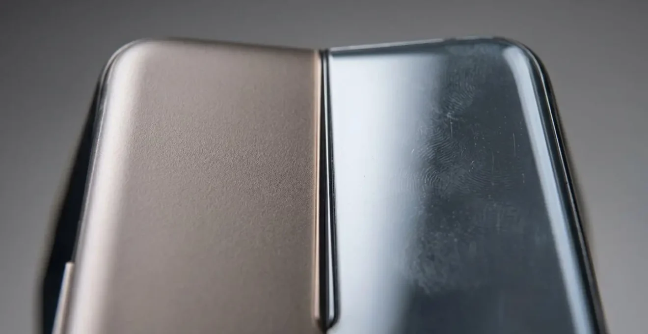Close-up textural comparison of polymer and glass phone back materials emphasizing tactile durability differences