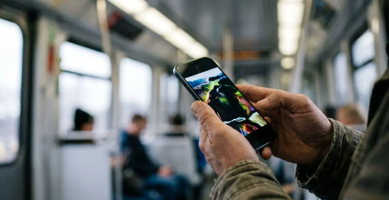 Person watching HDR movie content on smartphone during train commute in changing ambient light conditions