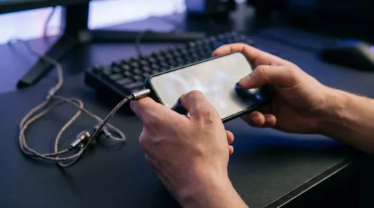 Mobile gaming scene showing competitive player using headphones with spatial audio cues visualization